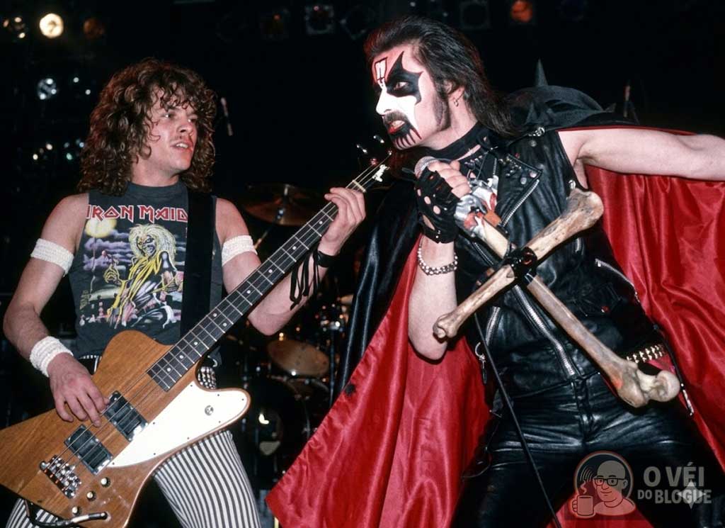 King Diamond com pintura corporal e cruz de ossos em show do Mercyful Fate nos anos 80, representando a estética oculta do metal extremo.