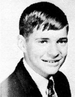Foto de anuário escolar de David Lee Roth na adolescência, vestindo terno e gravata com cabelo curto e escuro, antes da fama com o Van Halen